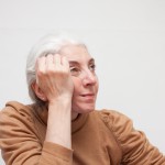 頭を抱えるシニア女性
